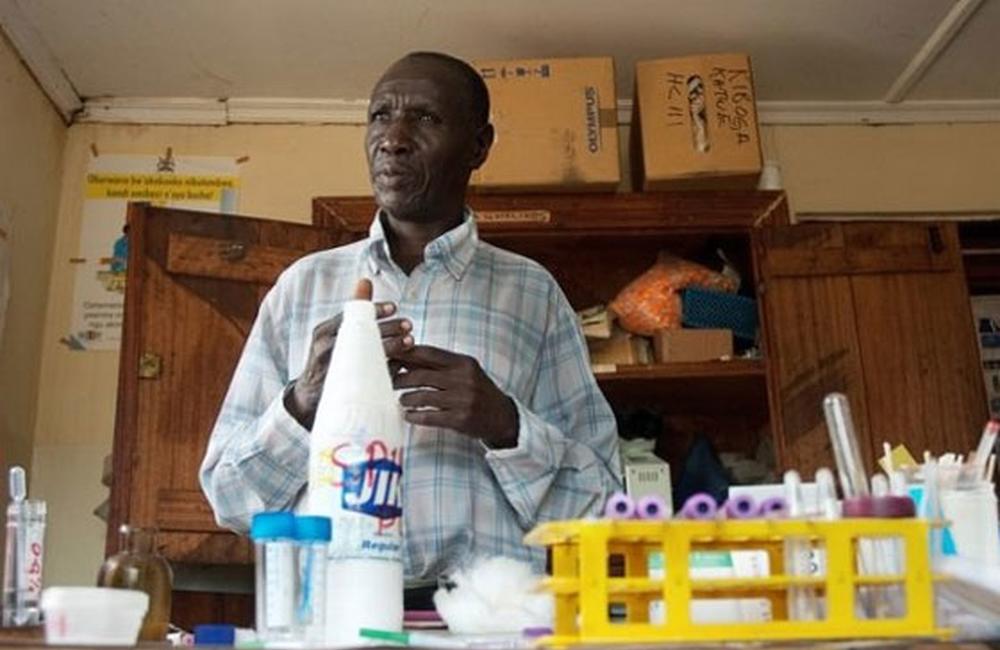A lab technician at work in Uganda. Diagnostic equipment in rural health centres is often rudimentary. AMREF is helping to upgrade labs in Kiboga and Luwero districts. Image ©AMREF www.amrefuk.org