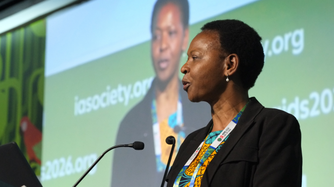 Dr Mutsa Bwakura Dangarembizi at AIDS 2026. She is talking into a microphone with a screen behind her.