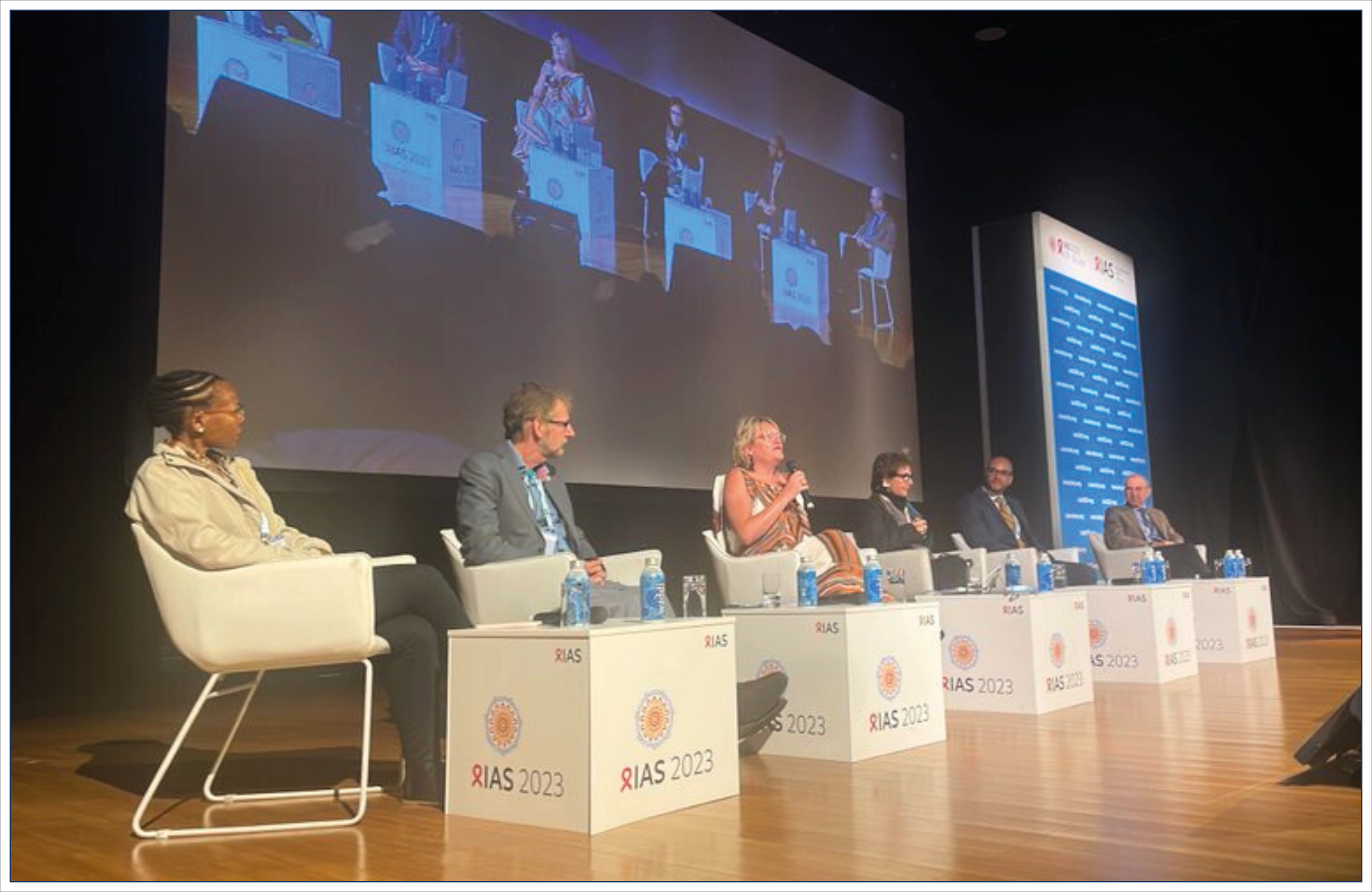 People seated on stage as part of a conference panel.