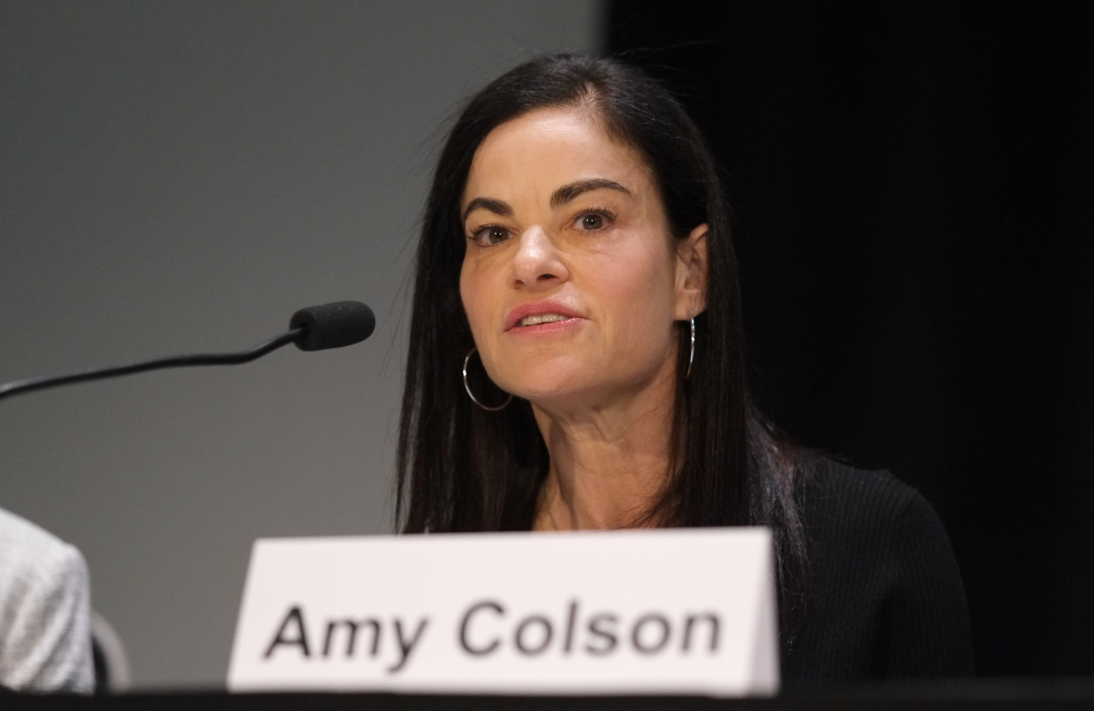 Dr Amy Colson speaking at a media briefing at CROI 2025. She is talking into a microphone.