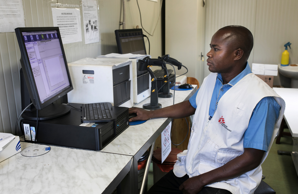 Haba Pokpa, MSF Lab Technician in the MSF supported laboratory in Matam health centre, Conakry, Guinea captures results from GeneXpert tests. Image by Albert Masais/MSF.