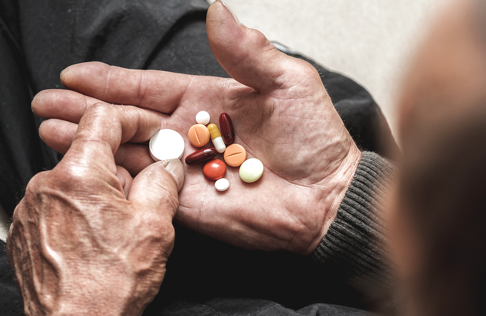 A man holding different tablets in his hand.