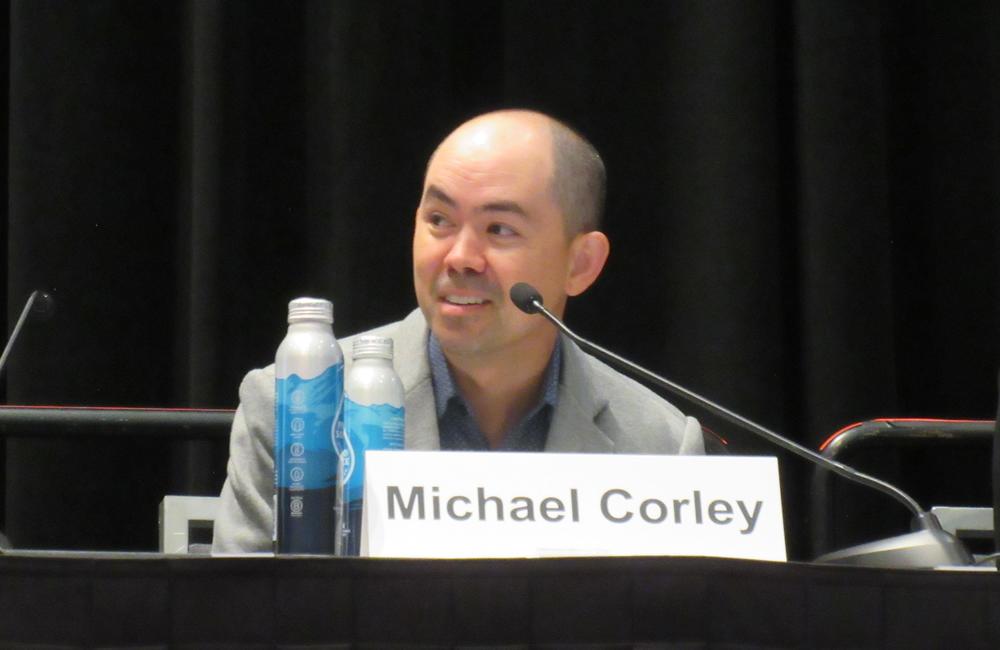 Dr Michael Corley at CROI 2025. Photo by Liz Highleyman. Dr Michael Corley speaking at a conference.