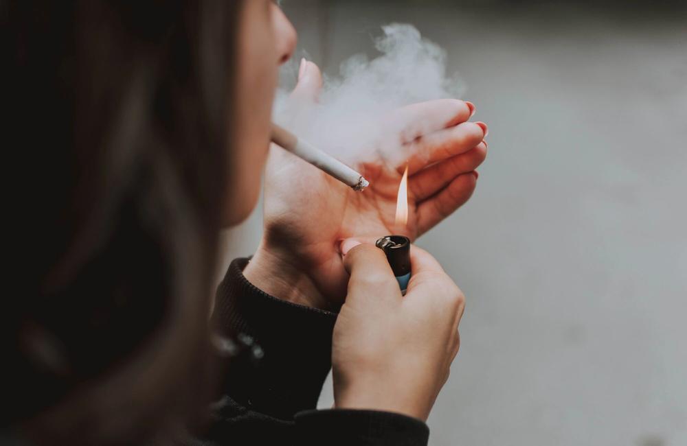 Pexels A woman lights a cigarette.