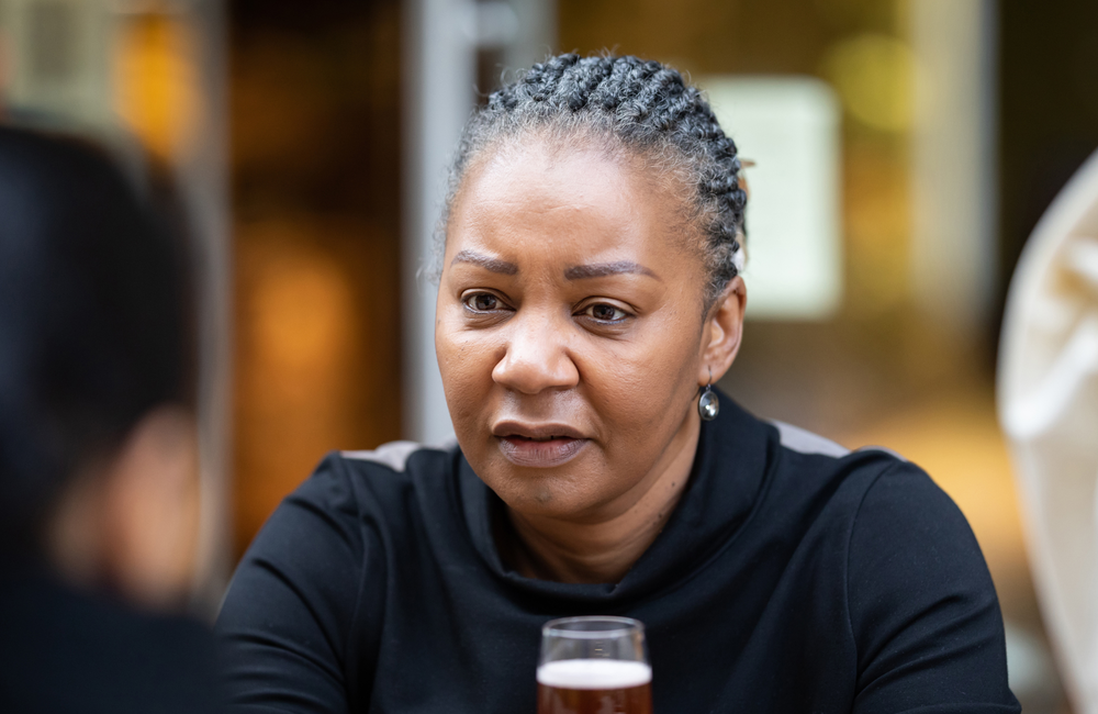 Image credit: HIV in View A woman is having a conversation with someone at a table.