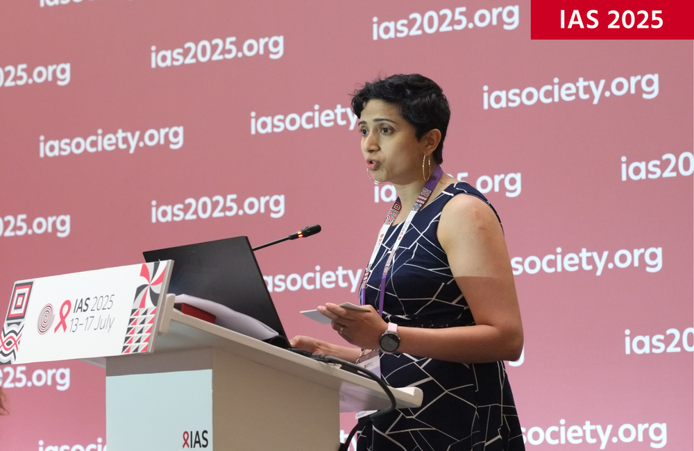 Rouella Mendonca, Director of AI Product at Audere, at IAS 2025. Image: Roger Pebody. Rouella Mendonca, Director of AI Product at Audere, at IAS 2025. Rouella is standing at a podium and talking into a microphone.