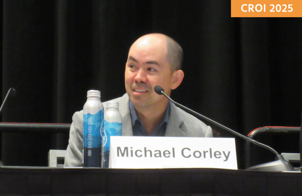 Dr Michael Corley at CROI 2025. Photo by Liz Highleyman. Dr Michael Corley speaking at a conference.