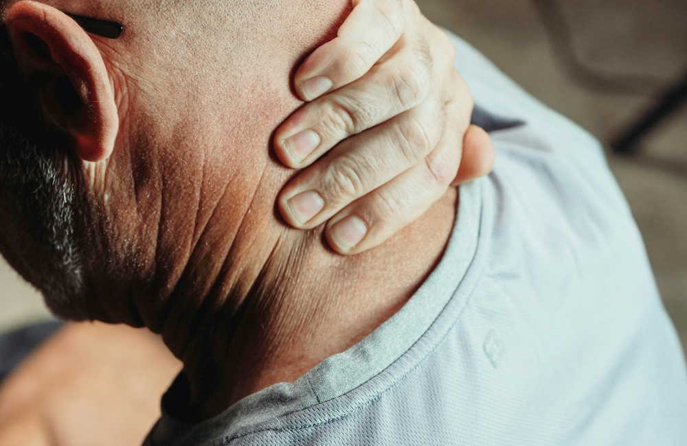 A man holds the back of his neck.