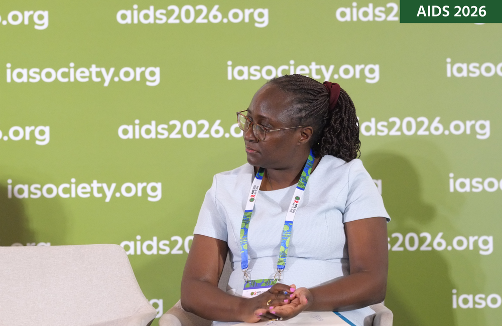 Linda Nabitaka at AIDS 2026. She is sitting down, looking off to her right. 