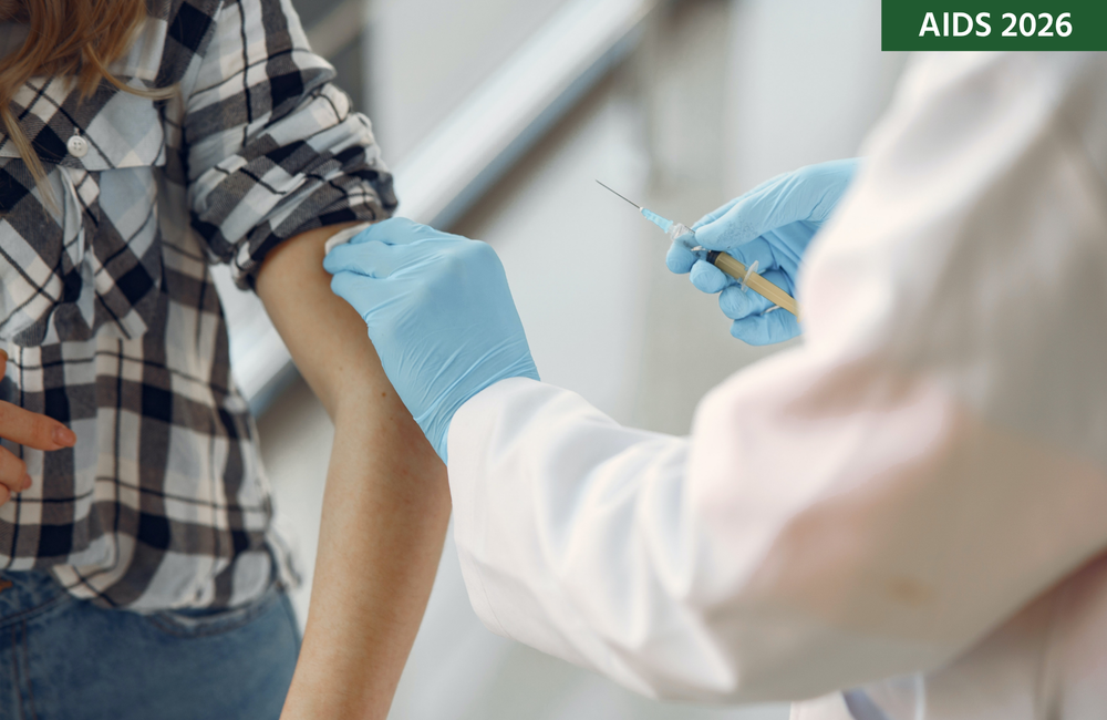 A doctor in a white coat and blue gloves prepares to vaccinate a person.